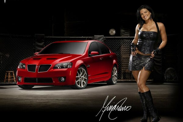 Dziewczyna w czarnej sukience na tle czerwonego samochodu