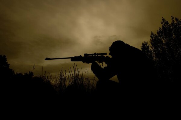 Snajper w ciemnym polu z bronią